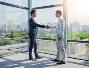fiducia marketing immobiliare incontro tra agente e cliente in ufficio con stretta di mano