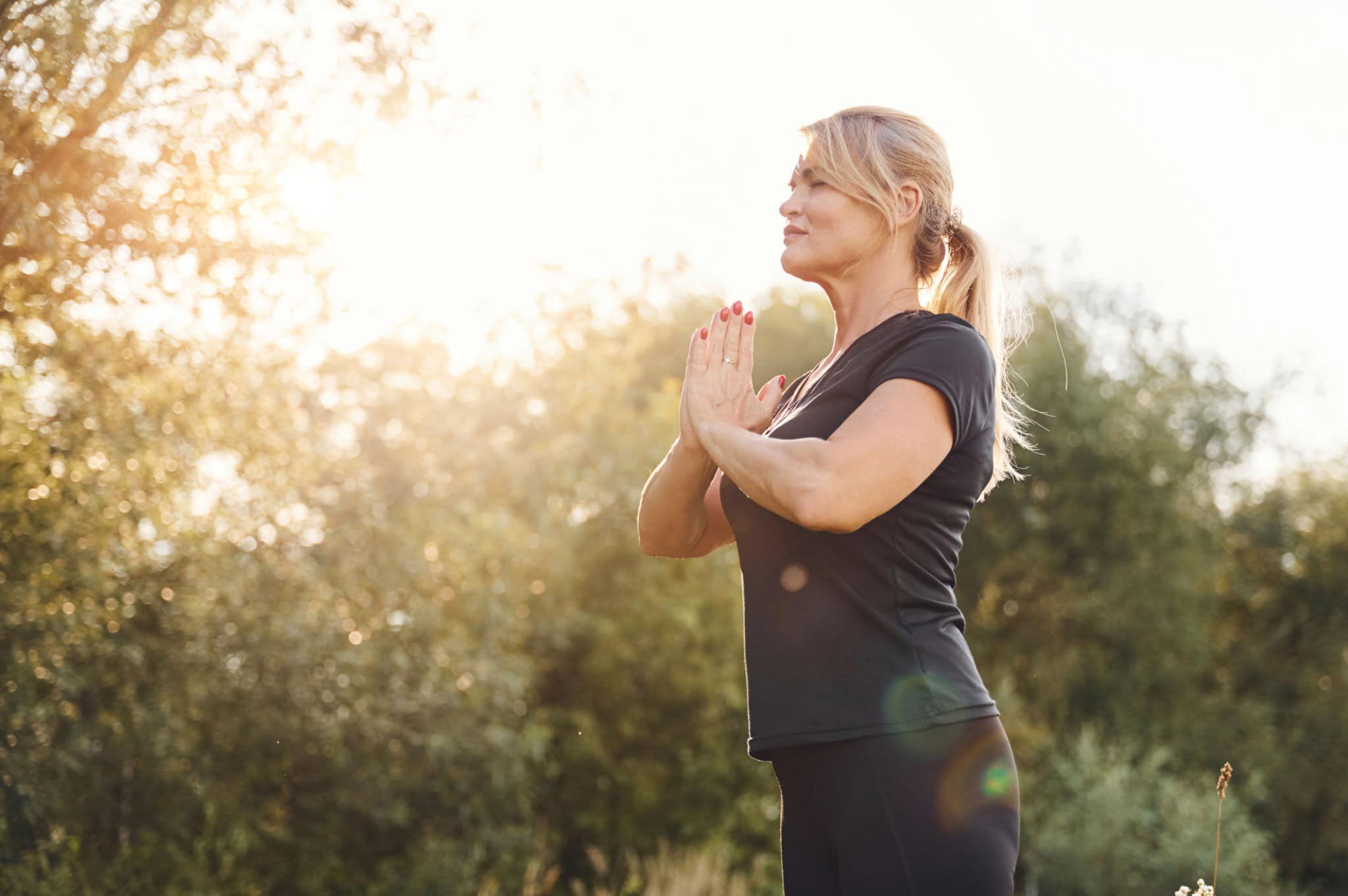 Gonfiore emotivo donne over 40 – donna over 40 che respira nella natura ritrovando calma ed equilibrio interiore