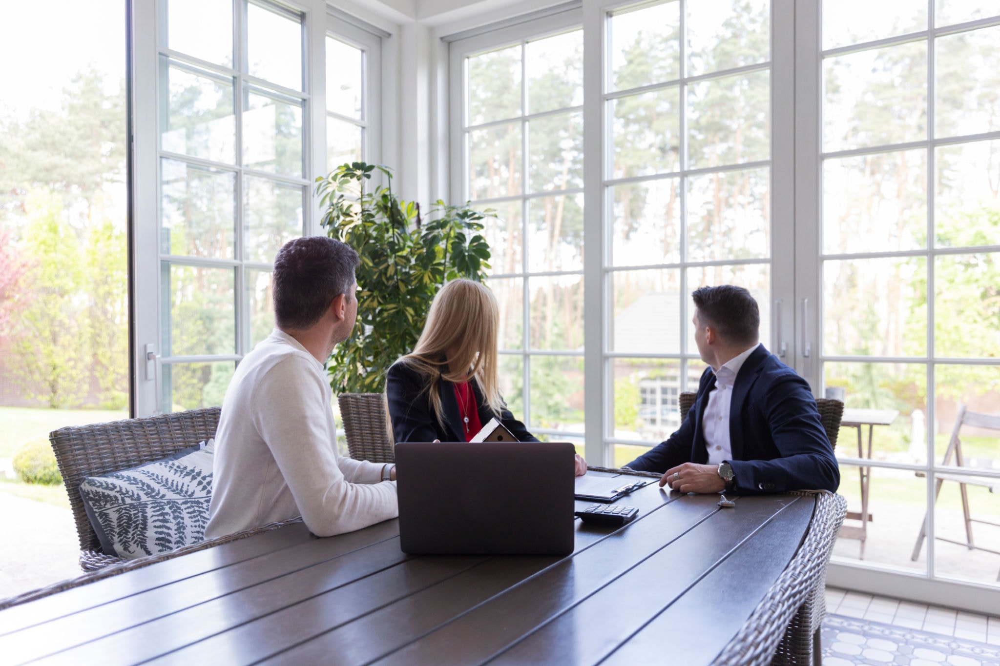 comunicazione persuasiva immobiliare agente spiega piano di vendita a coppia di venditori in ambiente luminoso