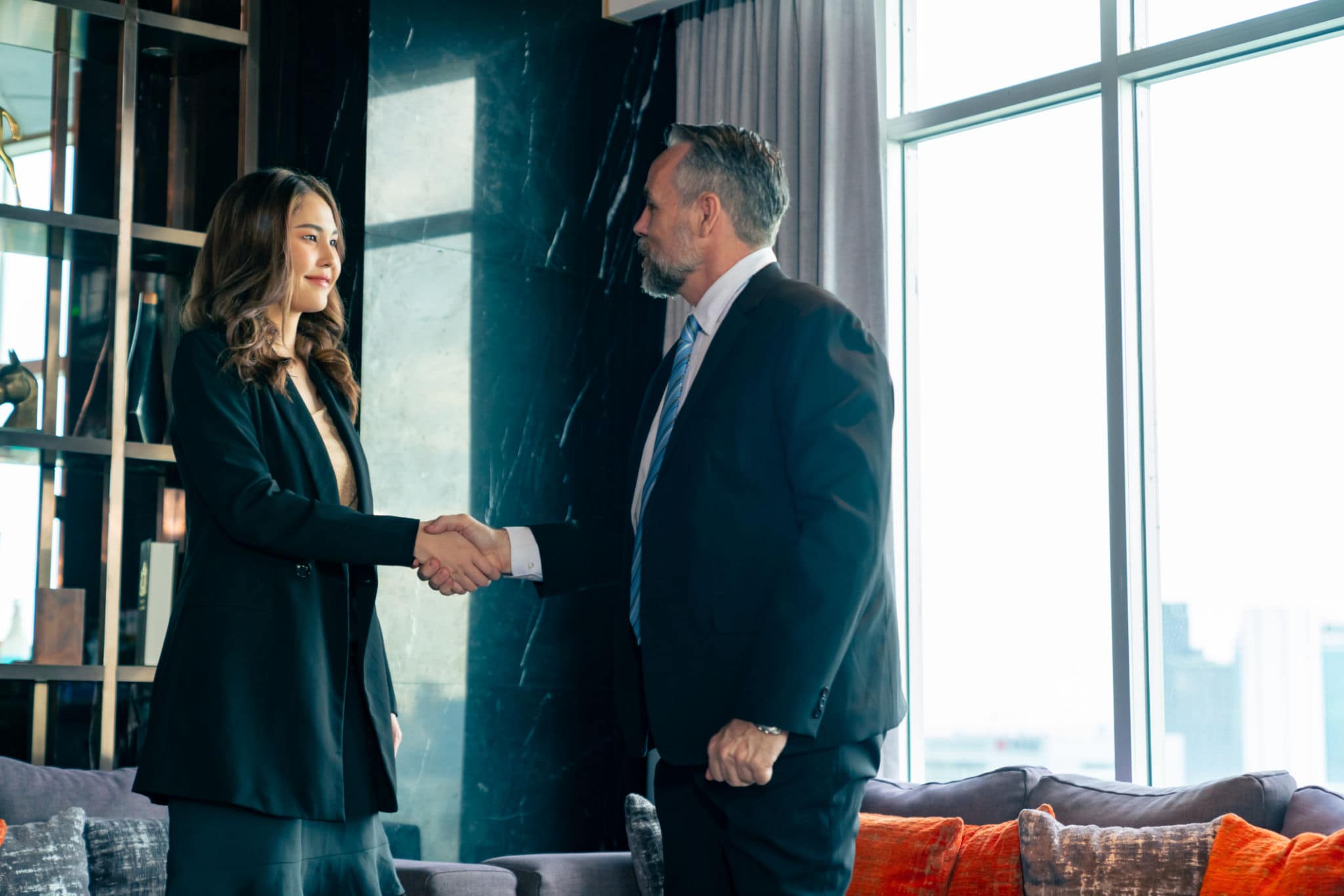 agente immobiliare che stringe la mano a un cliente in ufficio moderno, simbolo di fiducia e percezione di valore