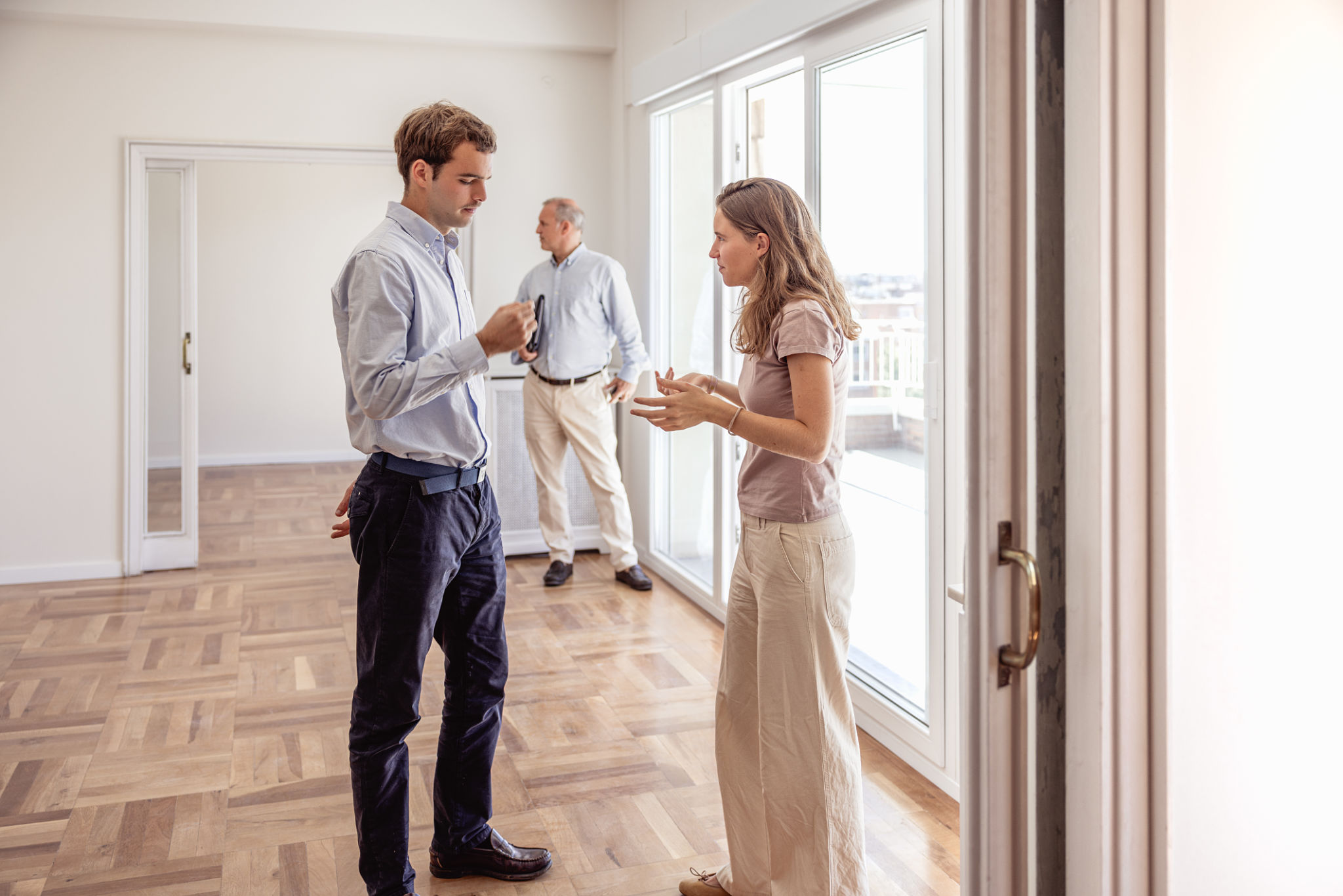 comunicazione immobiliare: agente al telefono durante consulenza con venditore e case in miniatura sul tavolo